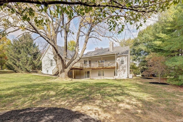 back of house featuring a wooden deck, a chimney, stairway, and a yard