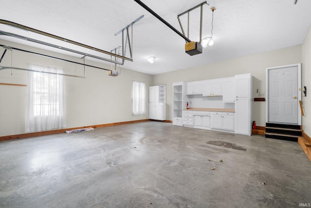 garage featuring a garage door opener and baseboards