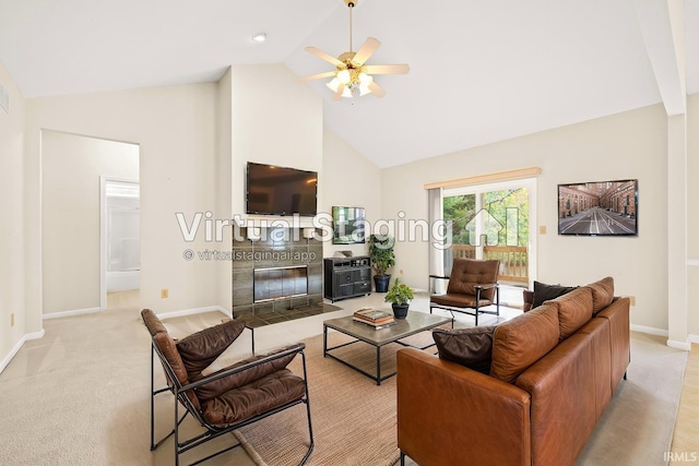 living room featuring light colored carpet, a ceiling fan, high vaulted ceiling, a tile fireplace, and baseboards