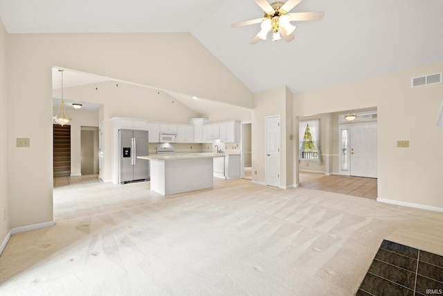 unfurnished living room featuring high vaulted ceiling, stairs, visible vents, and light colored carpet