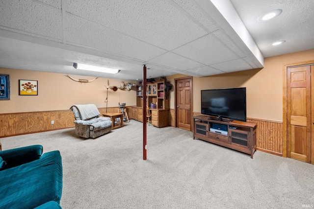 living area with wooden walls, wainscoting, carpet flooring, a paneled ceiling, and recessed lighting