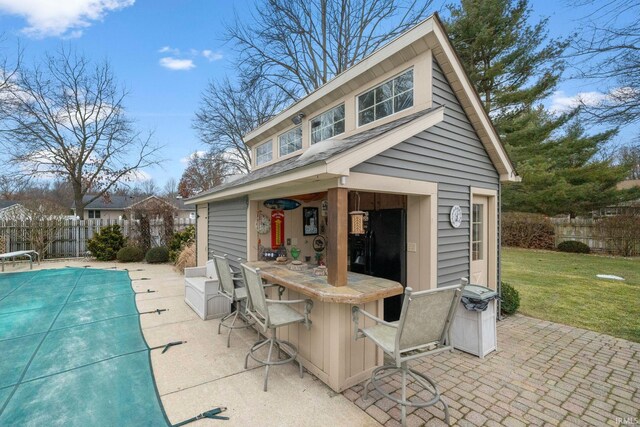 view of patio / terrace with outdoor dry bar, fence, and a fenced in pool