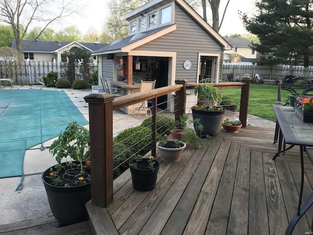 wooden deck with a fenced in pool, fence, and a lawn