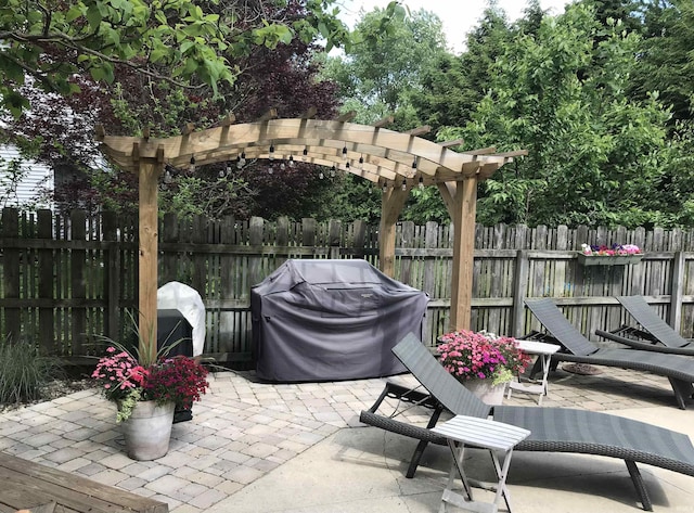 view of patio with fence, grilling area, and a pergola