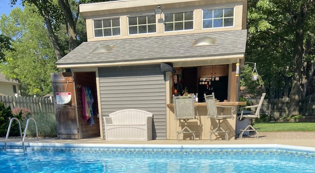 view of swimming pool with a sink, fence, outdoor dry bar, and a fenced in pool