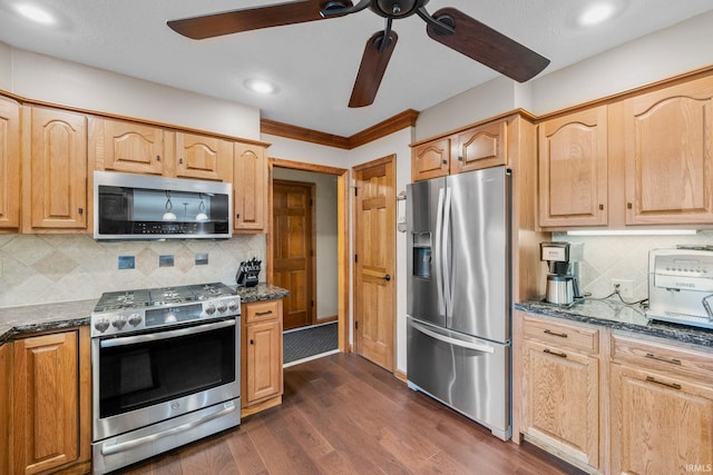 kitchen featuring tasteful backsplash, dark stone counters, ceiling fan, dark wood-type flooring, and stainless steel appliances