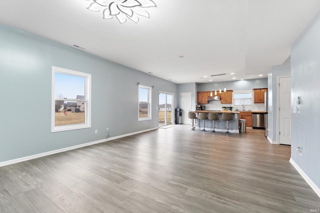 unfurnished living room with baseboards, visible vents, wood finished floors, and recessed lighting