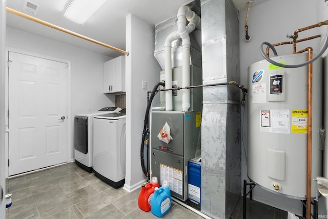 utility room featuring water heater, separate washer and dryer, and visible vents