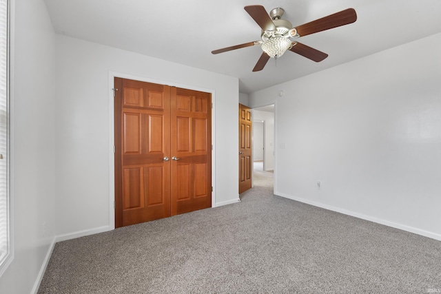 unfurnished bedroom featuring carpet, baseboards, ceiling fan, and a closet