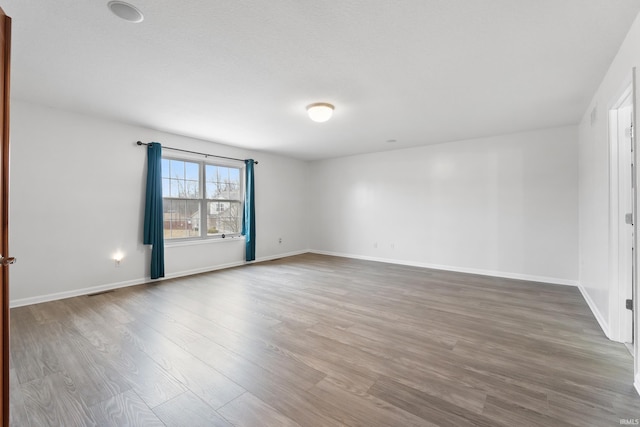 empty room with wood finished floors and baseboards