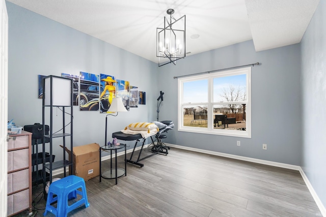 interior space featuring an inviting chandelier, wood finished floors, and baseboards