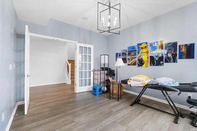 misc room featuring a chandelier, french doors, baseboards, and wood finished floors