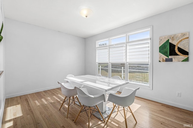 dining area featuring baseboards and light wood-style floors