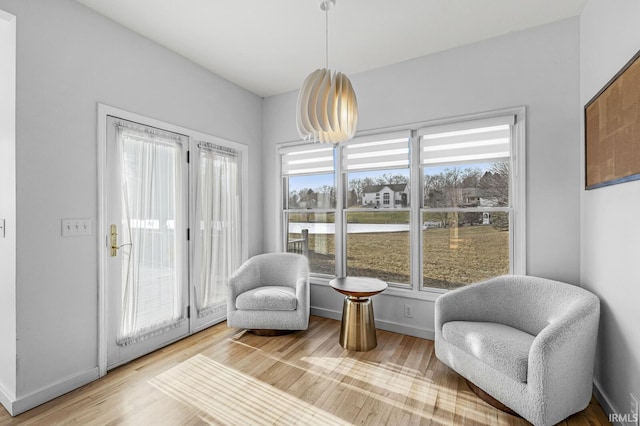 living area with light wood-style flooring and baseboards