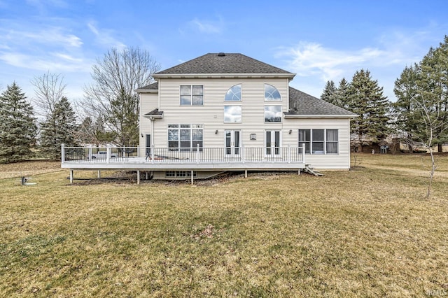 back of property with roof with shingles, a lawn, and a wooden deck