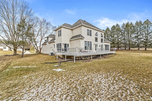 back of property featuring roof with shingles, a lawn, and a wooden deck