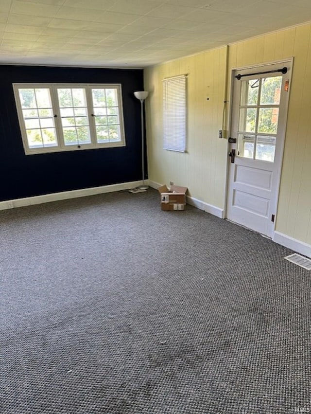 carpeted spare room with visible vents, plenty of natural light, and baseboards