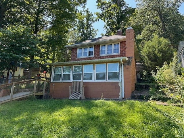 view of front of house featuring concrete block siding and a chimney