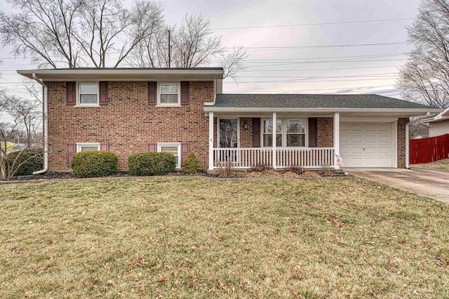 split level home with brick siding, a porch, a front yard, a garage, and driveway