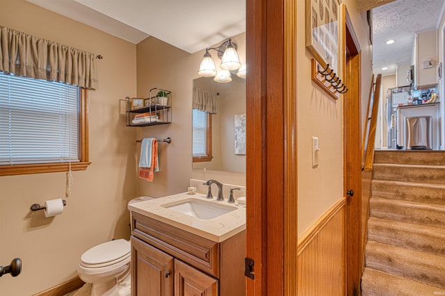 half bath featuring vanity and toilet