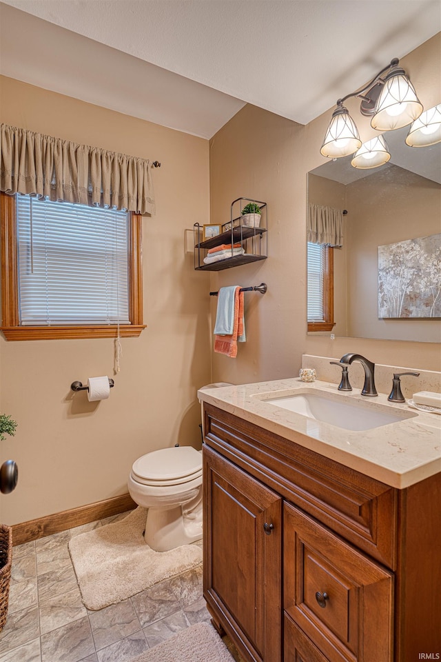 half bathroom with toilet, baseboards, and vanity