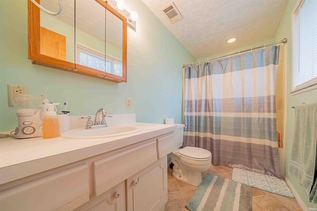 full bathroom with a textured ceiling, toilet, a shower with shower curtain, vanity, and visible vents