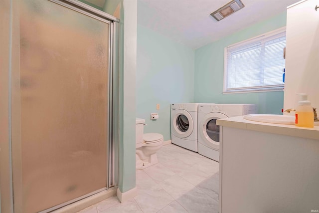 full bath featuring toilet, vanity, baseboards, washer and dryer, and a shower stall