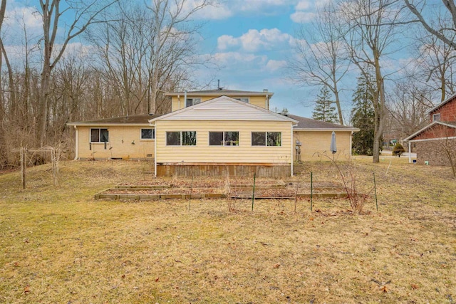 rear view of property featuring a lawn