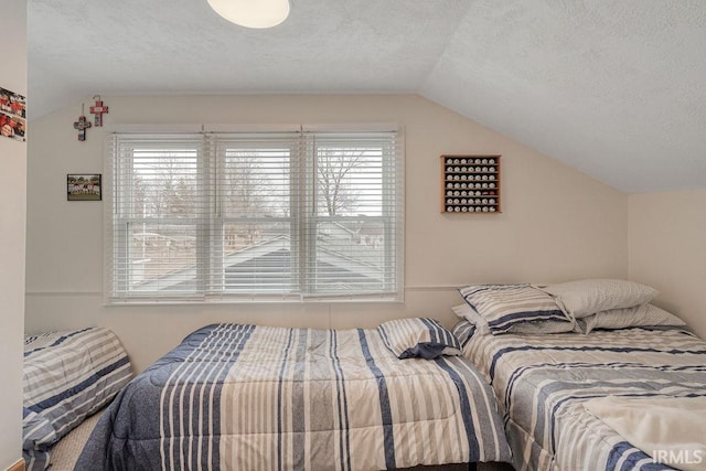 bedroom with vaulted ceiling and a textured ceiling