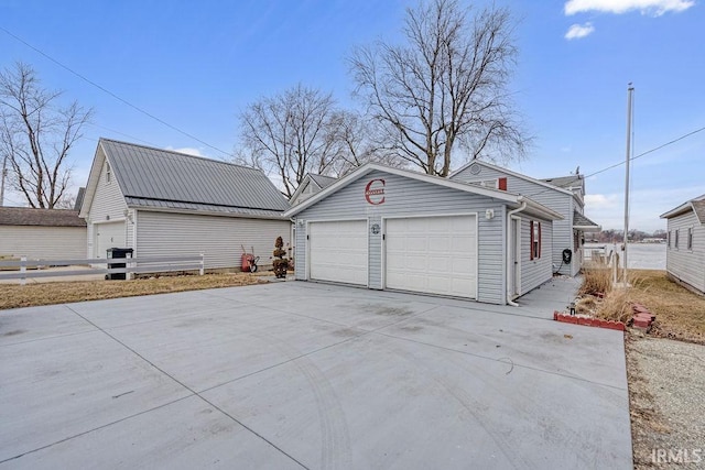 exterior space featuring a garage, metal roof, and driveway