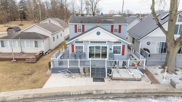 view of front facade featuring a deck, a patio area, and a front yard