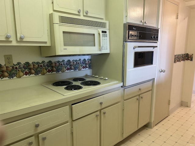 kitchen with light countertops, white appliances, and light floors