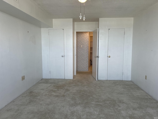 unfurnished bedroom with a textured ceiling and carpet flooring