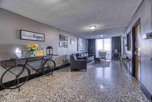 living area featuring a textured ceiling and baseboards