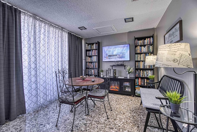 dining space with attic access and a textured ceiling