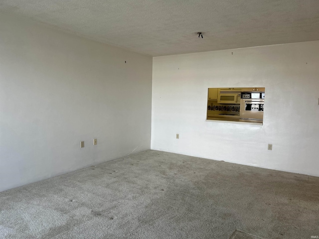 carpeted spare room with a textured ceiling