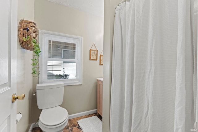 bathroom featuring toilet, baseboards, and vanity