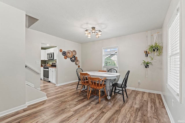 dining space featuring light wood-style floors and baseboards