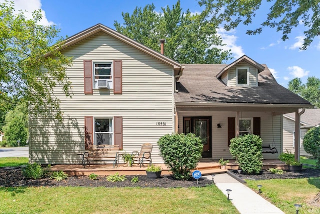 view of front facade featuring covered porch, cooling unit, and a front yard