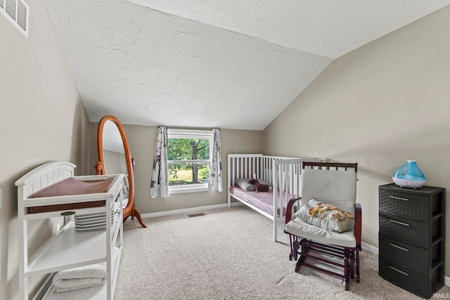 bedroom featuring lofted ceiling, a textured ceiling, carpet flooring, visible vents, and baseboards