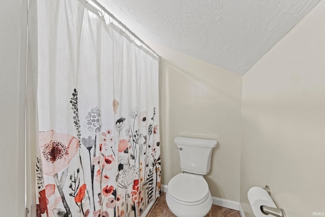 full bathroom with a textured ceiling, lofted ceiling, curtained shower, toilet, and baseboards