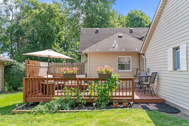 wooden deck with a lawn and fence