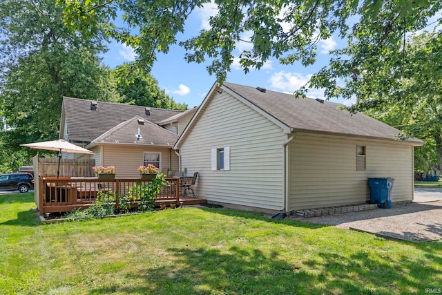 back of property with a deck and a yard