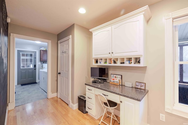 bar with recessed lighting, light wood-style flooring, washing machine and dryer, built in study area, and baseboards