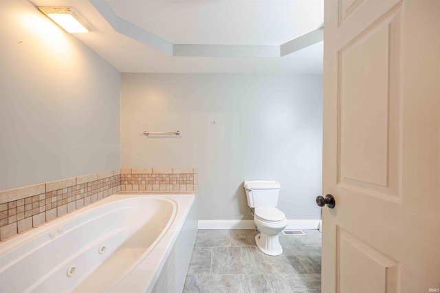 full bath featuring toilet, visible vents, baseboards, a whirlpool tub, and a raised ceiling