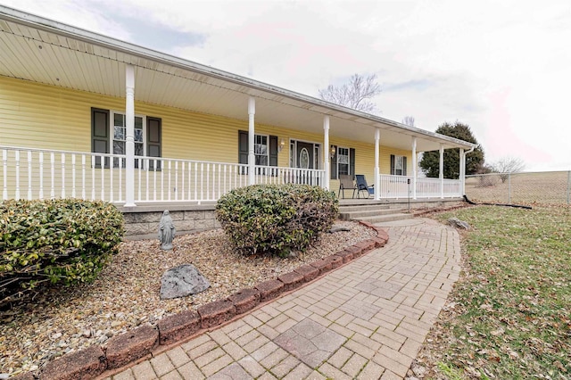 view of front facade with covered porch and fence