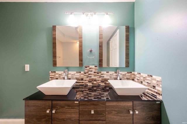 full bath with a sink, backsplash, and double vanity