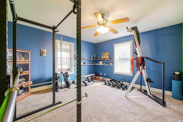 workout area featuring baseboards, carpet, a ceiling fan, and a healthy amount of sunlight