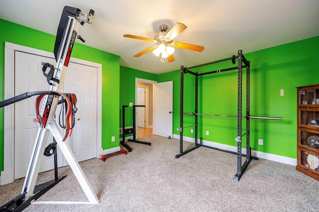 workout area with carpet flooring, a ceiling fan, and baseboards