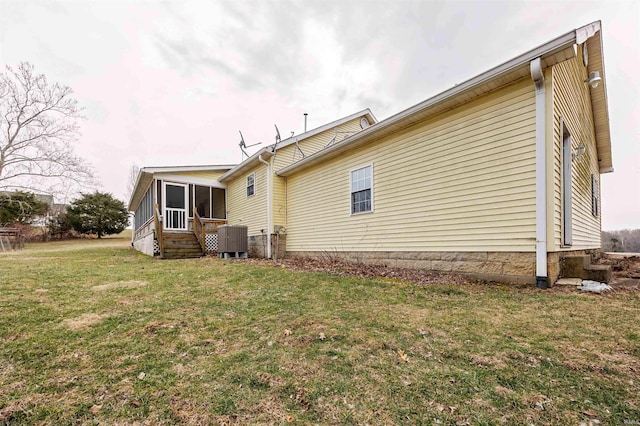 back of property featuring a sunroom, central AC unit, and a lawn